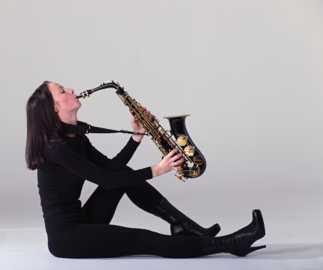 young woman in black with saxophone.