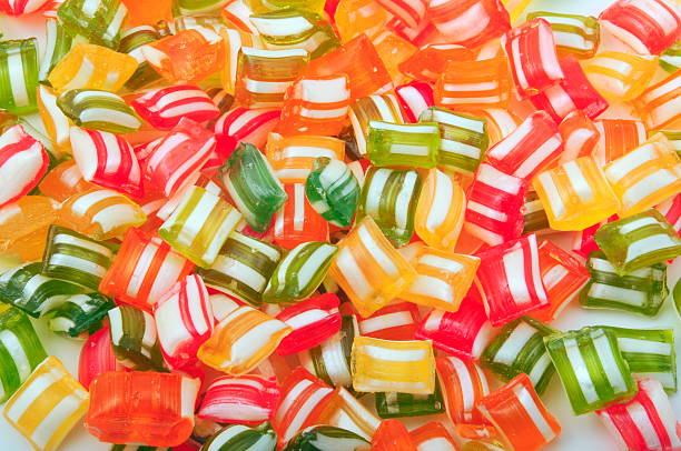 Background of multicolored hard candies with white stripes stock photo