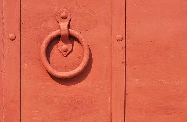 Red painted old iron door with circle doorhandle