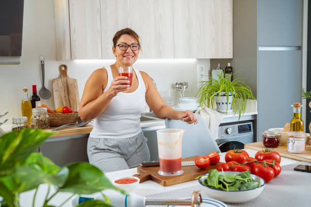 istock Smiling mature woman looking at camera drinking freshly blended tomato juice 1769128663