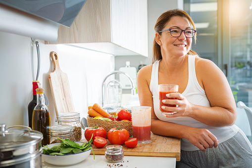 Woman enjoying freshly blended tomato juice for a healthy breakfast