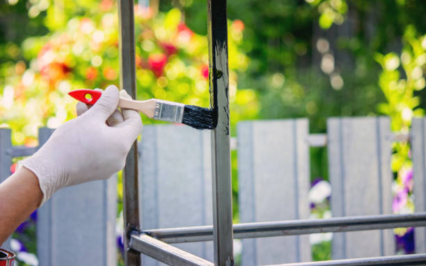 istock a man paints metal with black paint with a brush. 1769180339