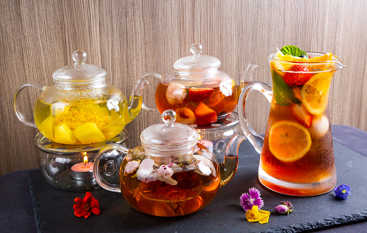 Assortment of scented tea or flower and Fruit black tea served in teapot and jar isolated on table side view of japanese beverages drink