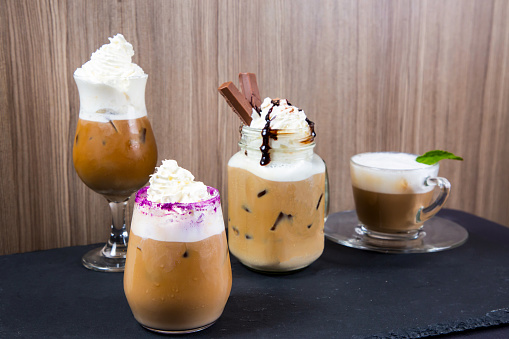 Assortment of specialty cold creamy coffee with chocolate served in jar isolated on table side view of cold dessert beverage on table