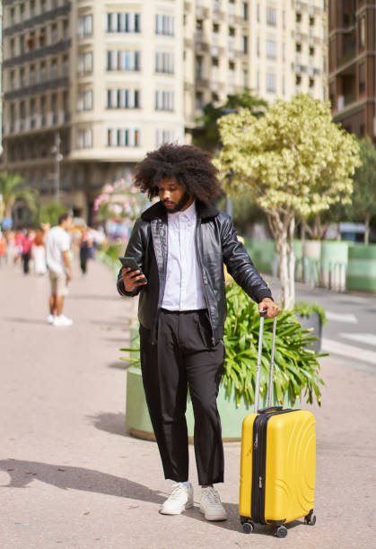 istock a young man walking around the city with a suitcase using a mobile phone 1769248644