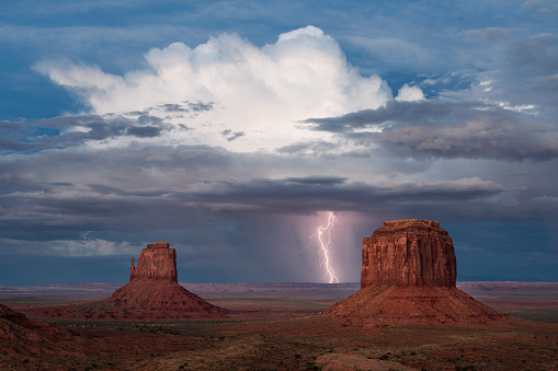 A monsoon thunderstorm drops cloud to ground lightning over Monument Valley, Arizona