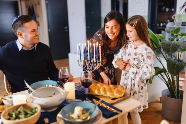 istock Mother and daughter lighting Menorah at the dining table 1769277881