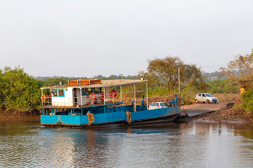 This image captures the scenic Chapora River in Goa, a waterway that winds its way through various towns and villages, reflecting both the natural beauty and the vibrant local culture of the region. Boats of various sizes and purposes can be seen moored along the riverbanks or gliding across the water, ranging from small fishing boats to larger vessels designed for river cruises. The photograph also highlights the towns that line the river, each offering its own unique blend of architecture, from traditional Goan houses to more modern structures. The image aims to give viewers a comprehensive view of life along the Chapora River, showcasing its role as both a natural resource and a hub of local activity.