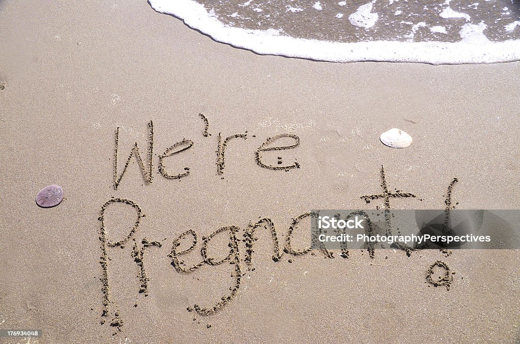 We're Pregnant! Written in beach sand "We are pregnant," a message written in the sand Announcement Message Stock Photo