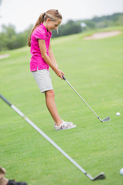 istock Young girl playing golf on green course 176936348