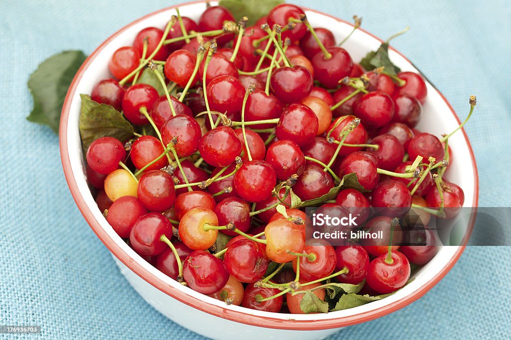 organic sour di ciliegie fresche e ciotola in tela grezza blu - Foto stock royalty-free di Alimentazione sana