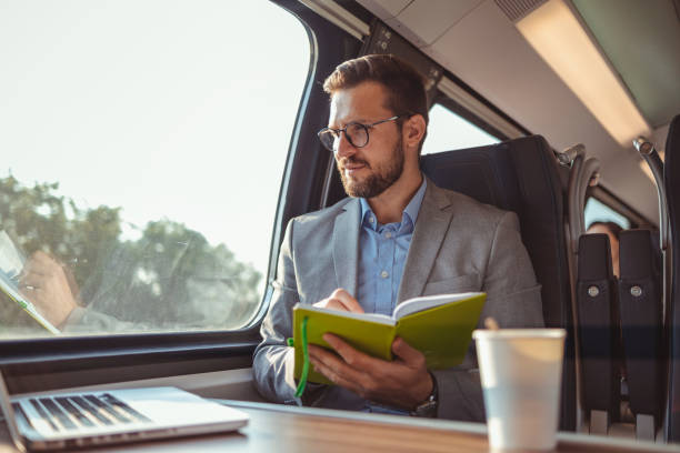 Businessman Writing in Notebook While Traveling With High-speed Train