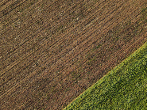 Plowed country field with soil in the morning from above