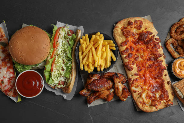 istock Burger, pizza and other fast food on black table, flat lay 1769400246