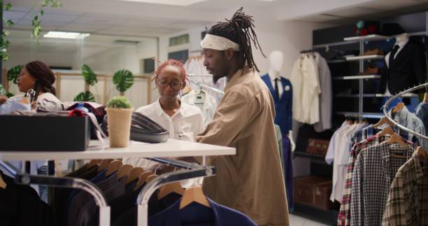 sh労働者から販売アドバイスを受ける男性 - clothing store store department store fashion ストックフォトと画像