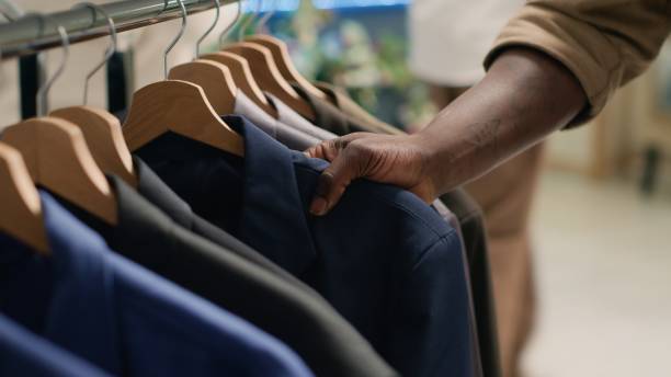 istock Man browses clothes racks in thrift shop 1769412158