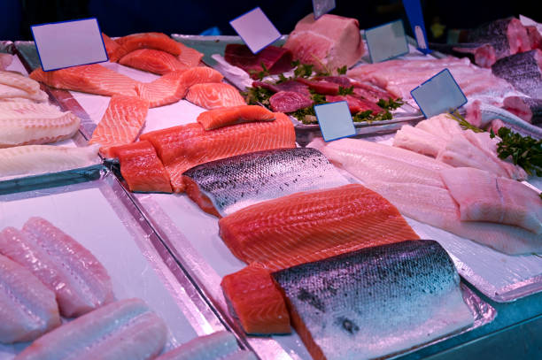 istock Nice fish counter featuring vibrantly colored salmon fillets. Alongside fillets of other varieties of fish and some parsley leaves. Copy space on white cards. 1769413013