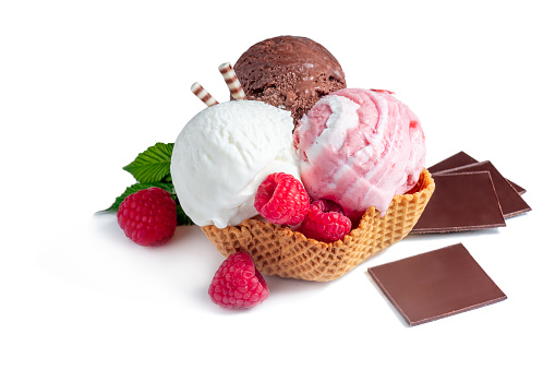 Three different scoops of ice cream lie in a waffle basket on a white background