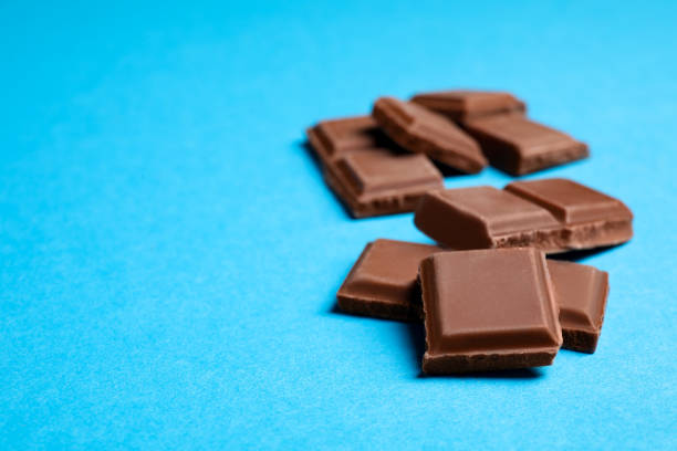 istock Pieces of delicious chocolate bar on light blue background. Space for text 1769462667