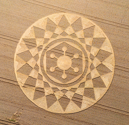 Aerial view of an intricate geometric crop circle formation in a wheat field in Wiltshire, England, UK