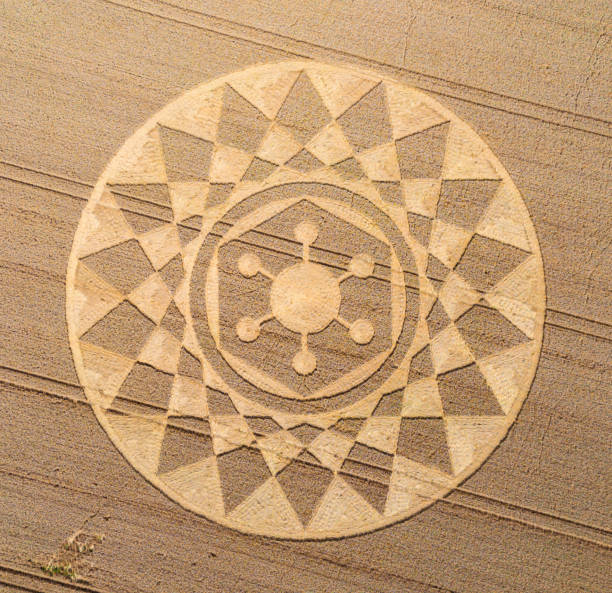Aerial view of an intricate geometric crop circle formation in a wheat field in Wiltshire, England, UK Aerial view of an intricate geometric crop circle formation in a wheat field in Wiltshire, England, UK crop circle stock pictures, royalty-free photos & images
