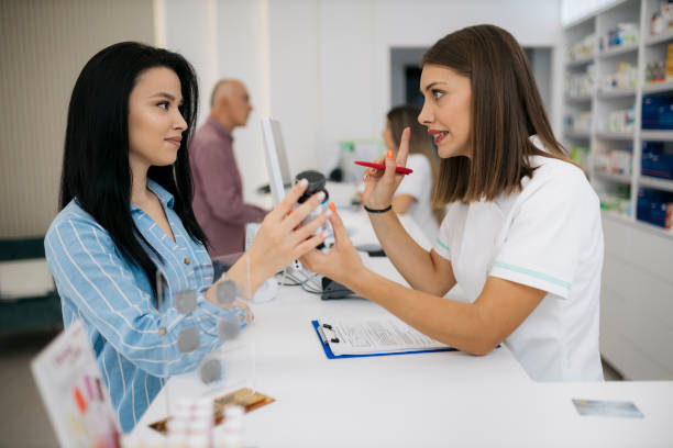 farmaceutka polecająca leki klientowi przy kasie - checkout counter pharmacy pharmacist patient zdjęcia i obrazy z banku zdjęć