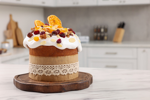 Delicious Easter cake with dried fruits on white marble table in kitchen. Space for text