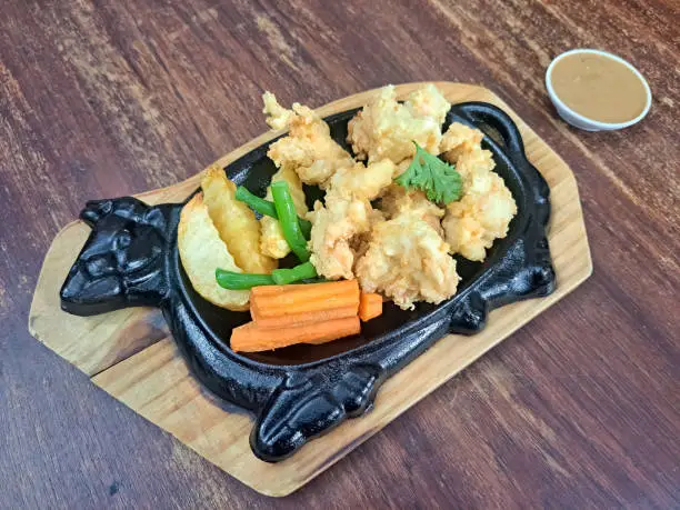 Photo of Hot Plate Crispy Chicken Steak With Potato Wedges, Long Bean, Carrot Sliced, Parsley And Brown Sauce. Food Menu