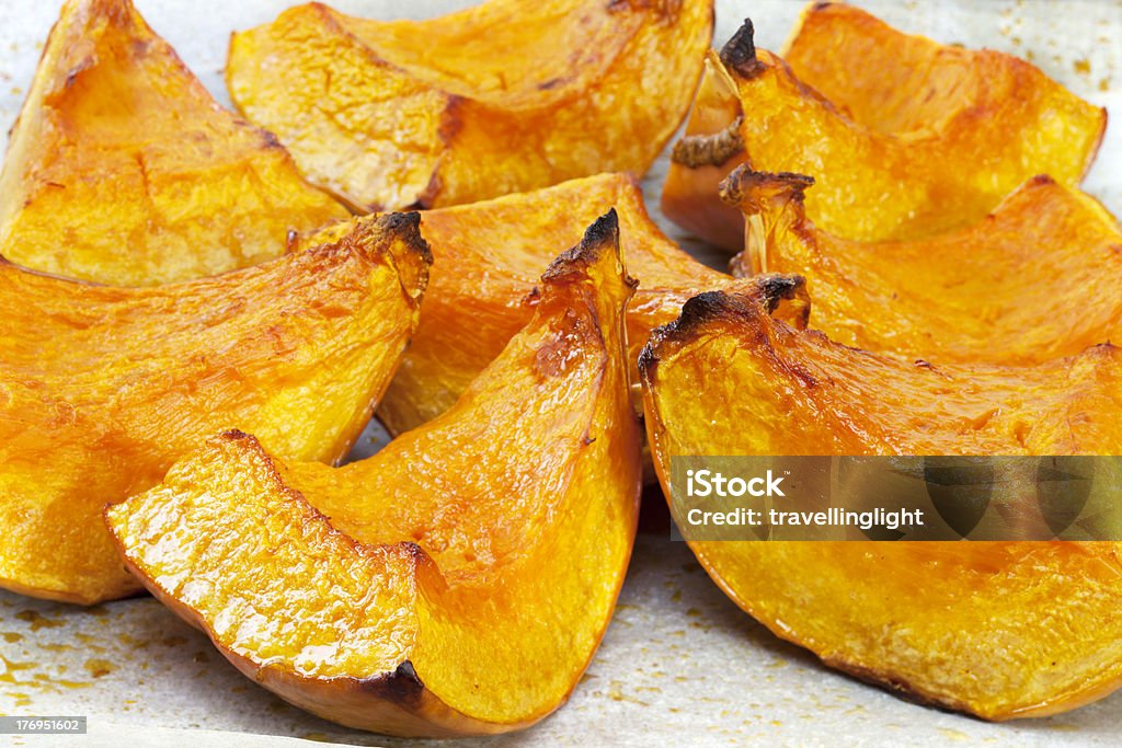 Roast Pumpkin "A tray of roast pumpkin, fresh from the oven, sitting on baking parchment." Baked Stock Photo