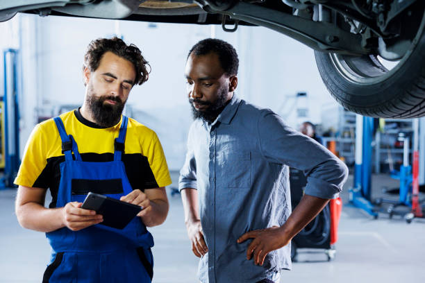 istock Employee checks car tires with client 1769517703