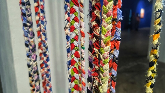 Some ropes made from braided patchwork with blurry background