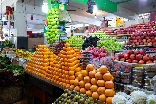 This image offers a glimpse into Margao's vegetable market in Goa, a vibrant marketplace teeming with fresh produce and local flavours. Stalls are adorned with a colourful array of fruits and vegetables, from locally-grown staples like okra and eggplant to exotic offerings like dragon fruit and rambutan. The atmosphere is lively, filled with the chatter of vendors and customers, and the air is perfumed with the earthy scent of fresh produce. The photograph aims to capture the essence of the market, portraying it as a hub of local activity where the community comes together to shop, socialise, and experience the bounty of Goa's agricultural offerings.