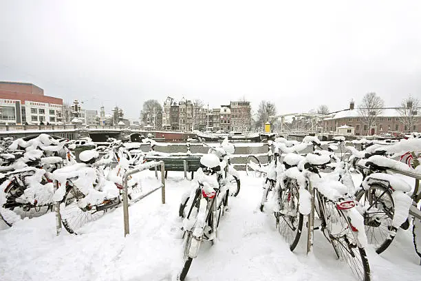 Snowy bikes in Amsterdam innercity near the Blauwbrug at the Amstel in the Netherlands