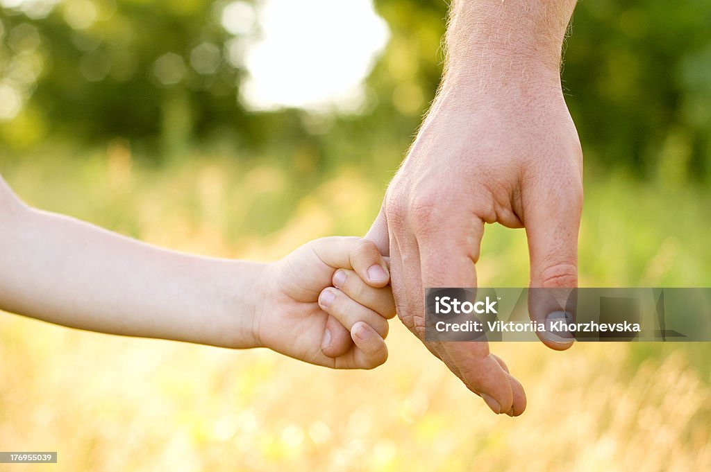father lead by the hand son father lead by the hand son summer outdoor Adult Stock Photo