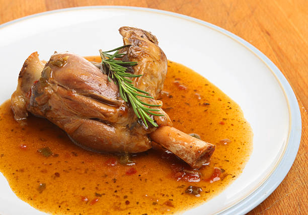 jarret d'agneau cuits dans du vin & sauce aux herbes - lamb shank photos et images de collection