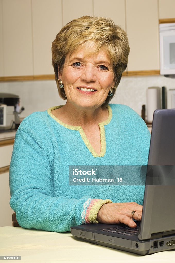 Frau arbeitet auf laptop in der Küche - Lizenzfrei 60-64 Jahre Stock-Foto