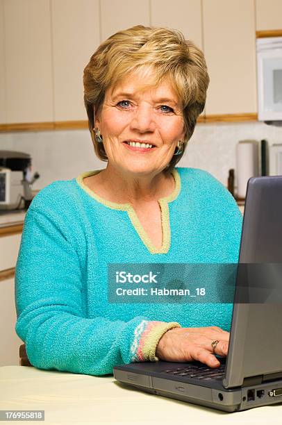 Foto de Mulher Que Trabalha Com O Laptop Na Cozinha e mais fotos de stock de 60 Anos - 60 Anos, 60-64 anos, Adulto