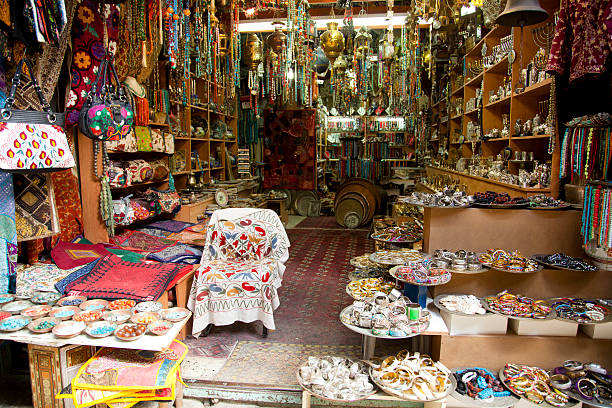 Market Tourist Shop "A tourist shop in the market of the old city of Jerusalem, containing a variety of merchandise such as necklaces, pillow cases,  beads, carpets, hand bags, Hanukkah candlesticks and more." hanukkah shopping stock pictures, royalty-free photos & images