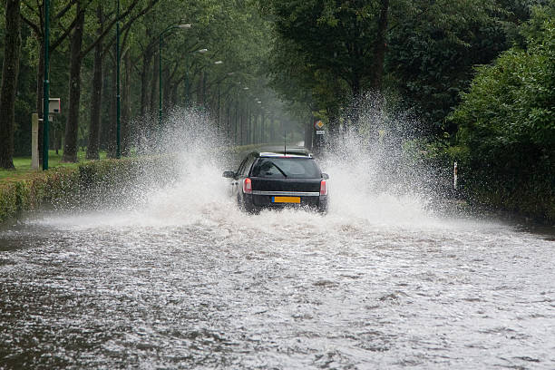 Car driving through a flooded street "Car driving through a flooded street (Baarn, the Netherlands)" walking in water stock pictures, royalty-free photos & images