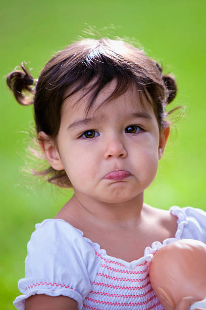 Baby girl with bottom lip stuck out pouting stock photo