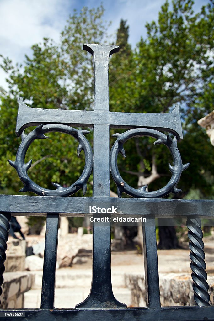 Gate Cross at Gethsemane A metal crucifix as part of gate decoration on the background of The Church of All Nations at Gethsemane, the place where Jesus Christ started his suffering prior to his crucifixion. All Nations Church Stock Photo