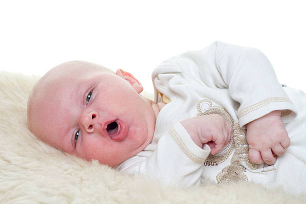 Little Baby Baby on a sheepskin. Baby is three month old. Studiolight with white background. sleep issues in babies stock pictures, royalty-free photos & images