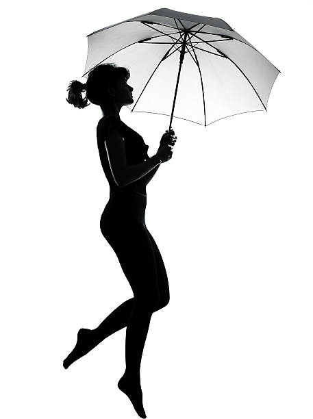 one silhouette woman flying holding open umbrella