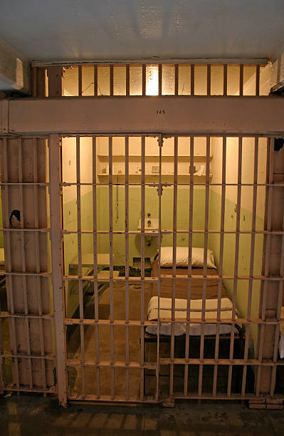 istock Outside of gloomy lit prison cell with closed bars 176958063