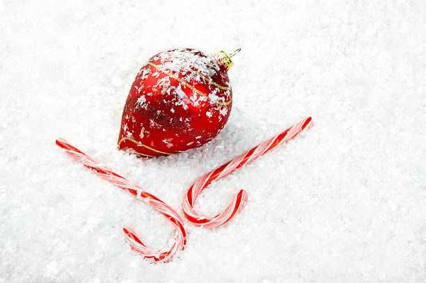 Candy Canes and Ornament lying in the snow stock photo