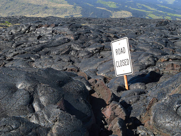 Road closure from eruption in Hawaii Road sign posted in lava field over Chain of Craters Road on the Big Island of Hawaii pavement ends sign stock pictures, royalty-free photos & images