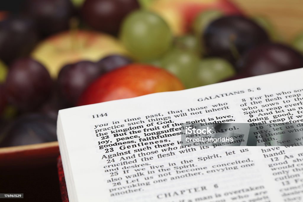 Fruit of the Spirit Holy Bible open to Galatians 5. Focus on verse 22. Fruit Stock Photo