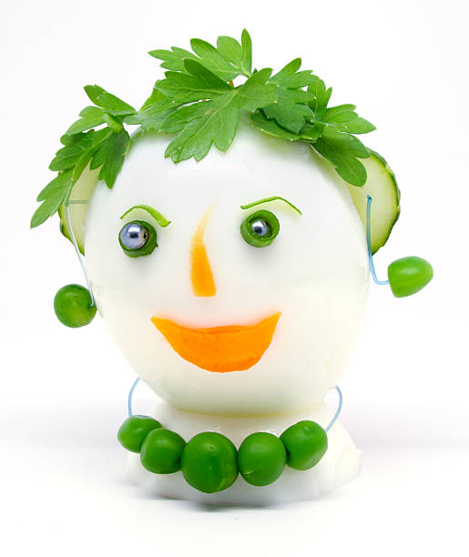 Egg garnished with parsley, cucumber, carrots and green peas stock photo