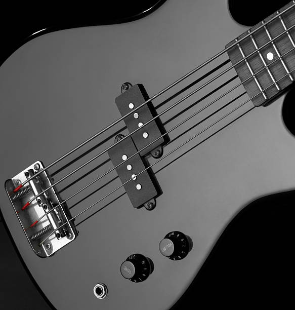 bass guitar detail of a black bass guitar in dark back regler stock pictures, royalty-free photos & images