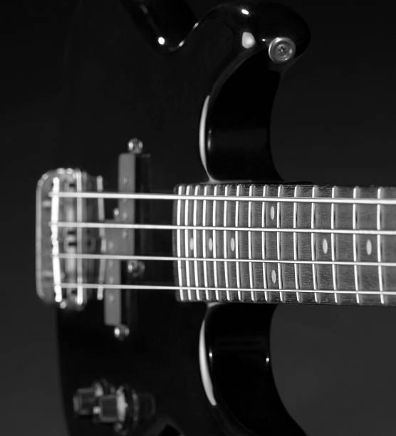 black bass guitar angle detail of a black bass guitar in dark back regler stock pictures, royalty-free photos & images
